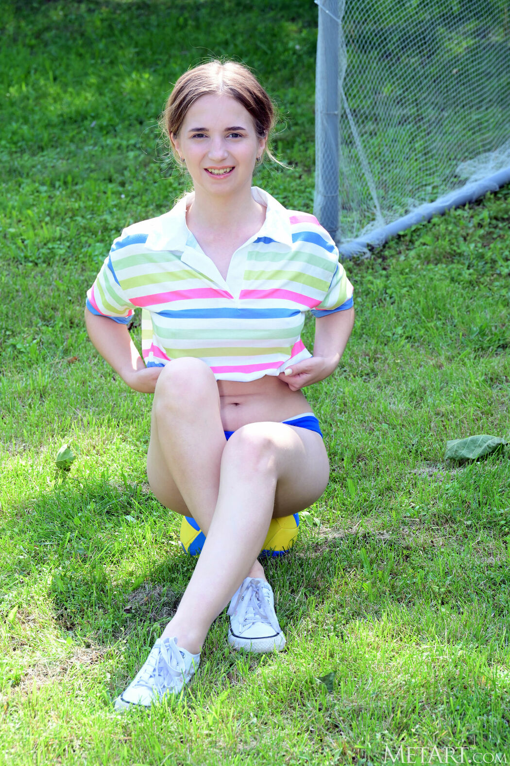Roze Kicks The Ball Playfully Across The Grass In Her Athletic Outfit
